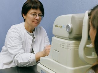 A healthcare professional conducts an eye exam using advanced technology in a clinical setting.